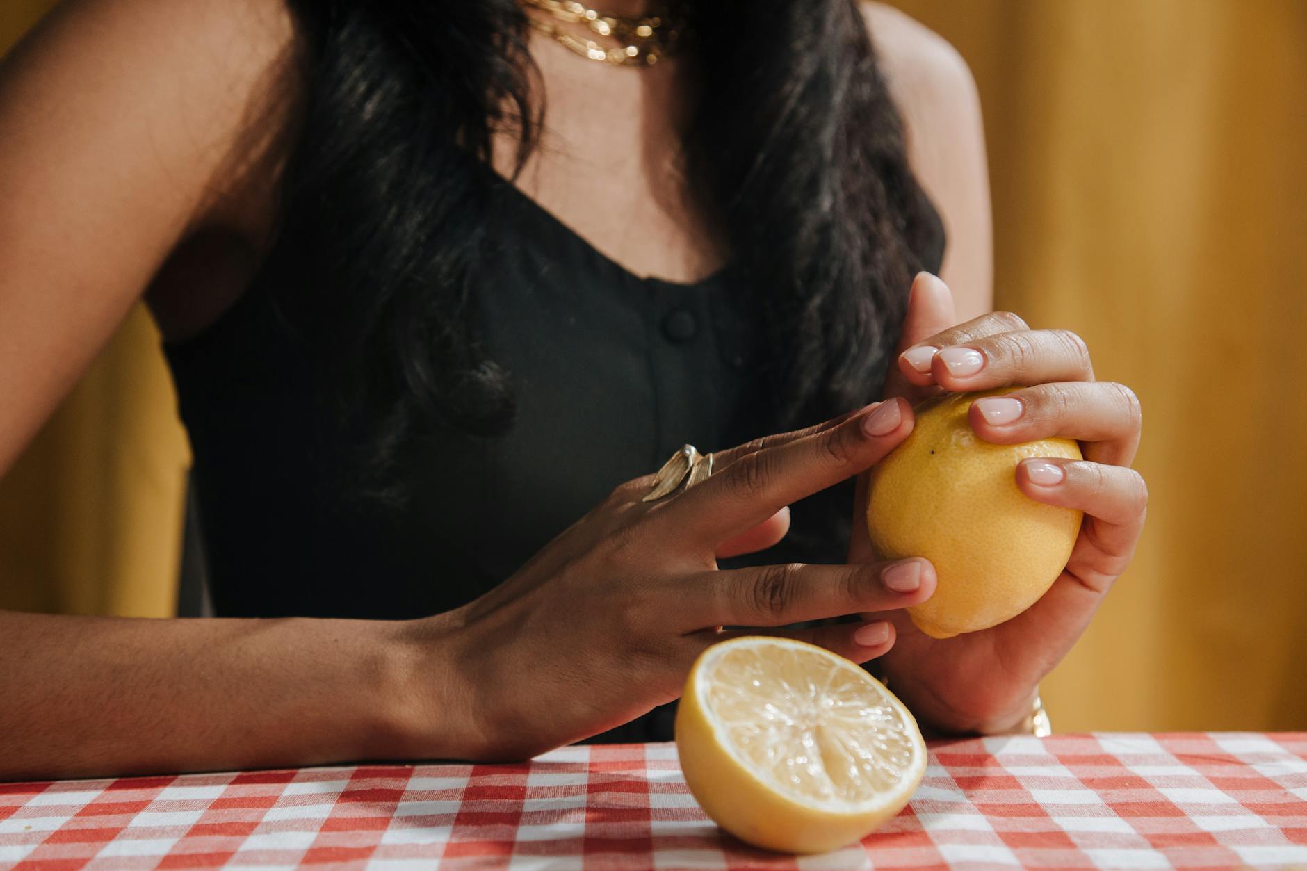 Woman holding a fresh lemon, relaxed and peaceful expression