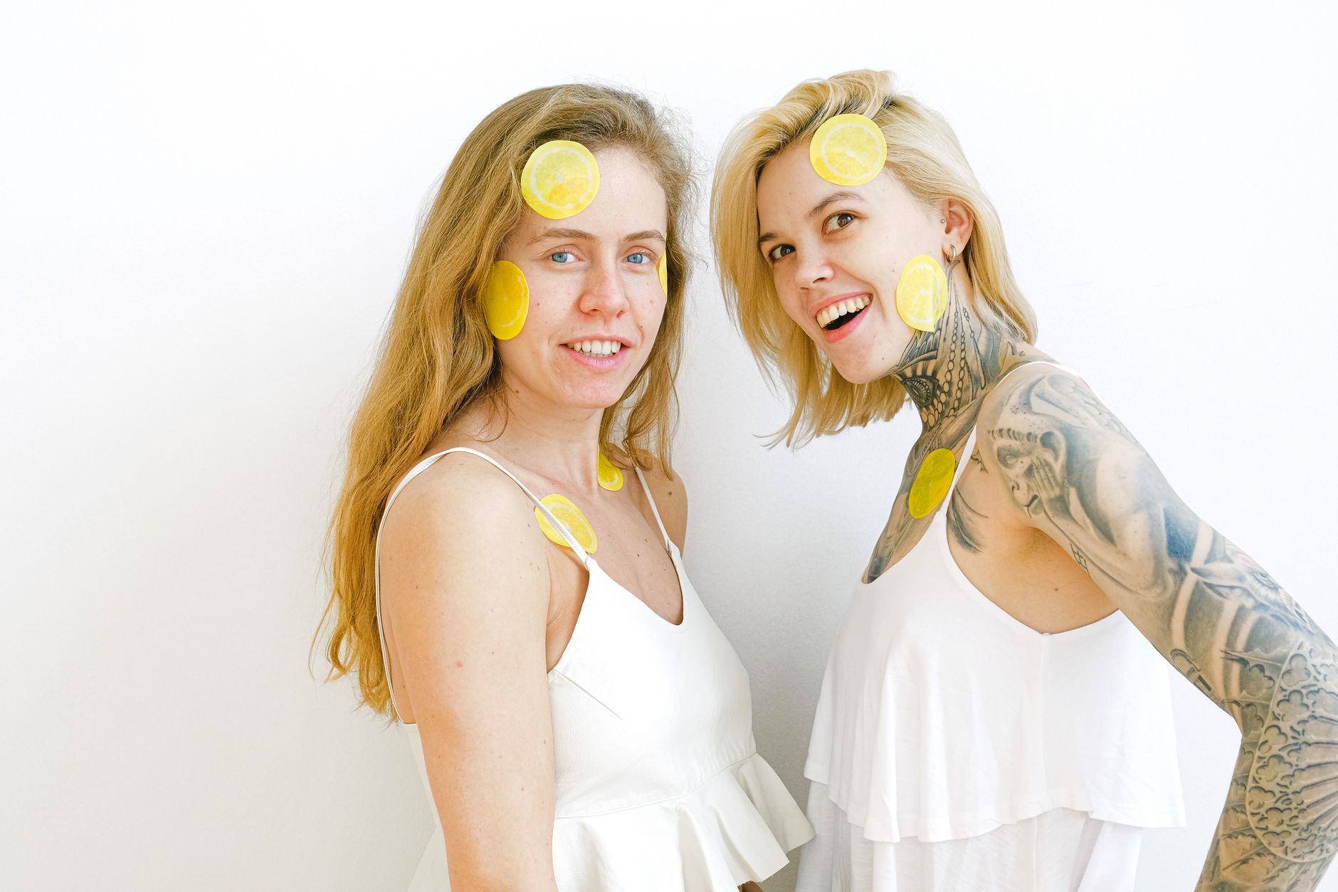 A blue vibrator surrounded by flowers and citrus slices on a bright background, symbolizing renewal and intimacy