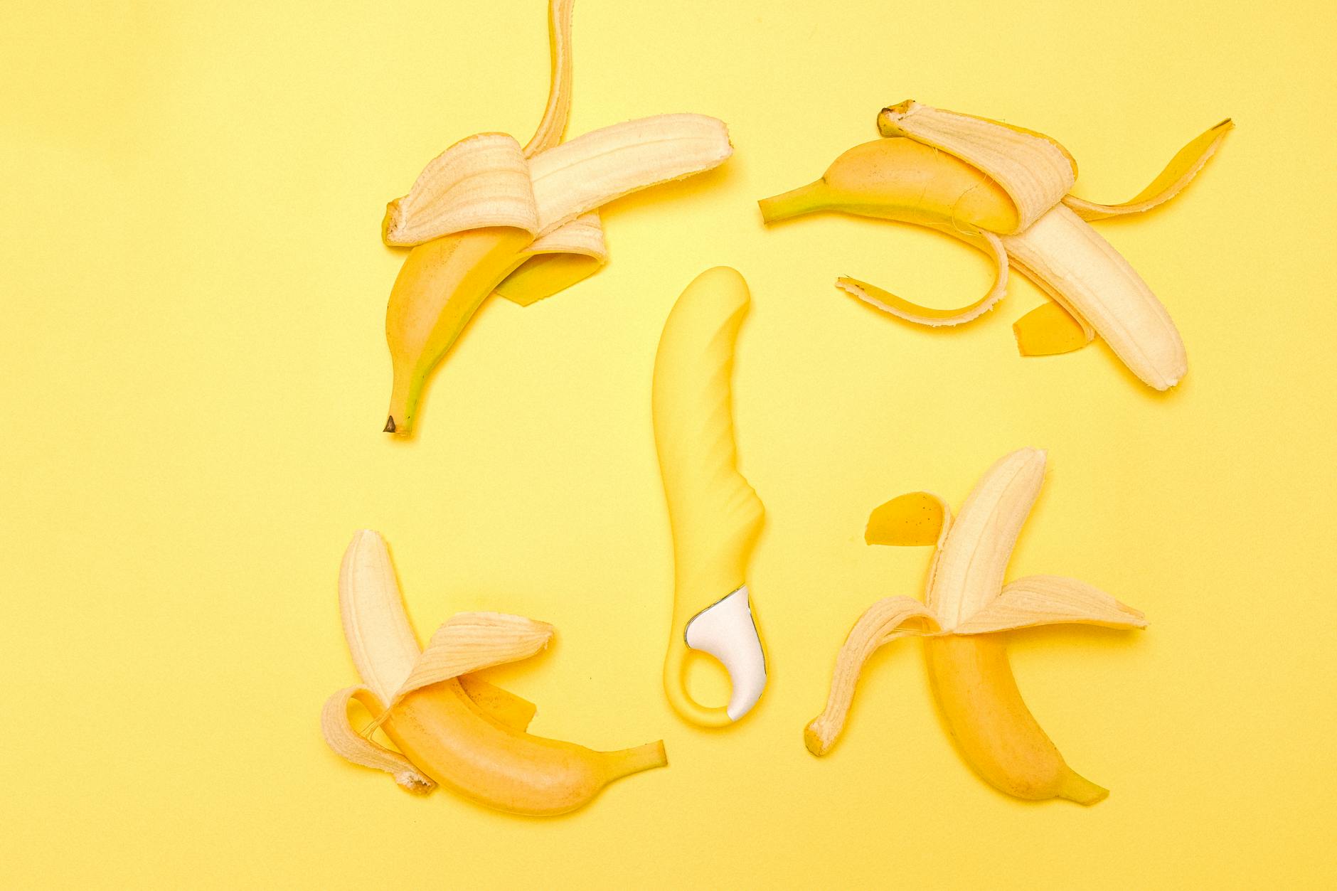 Vibrador de limão amarelo em close com limões descascados ao fundo
