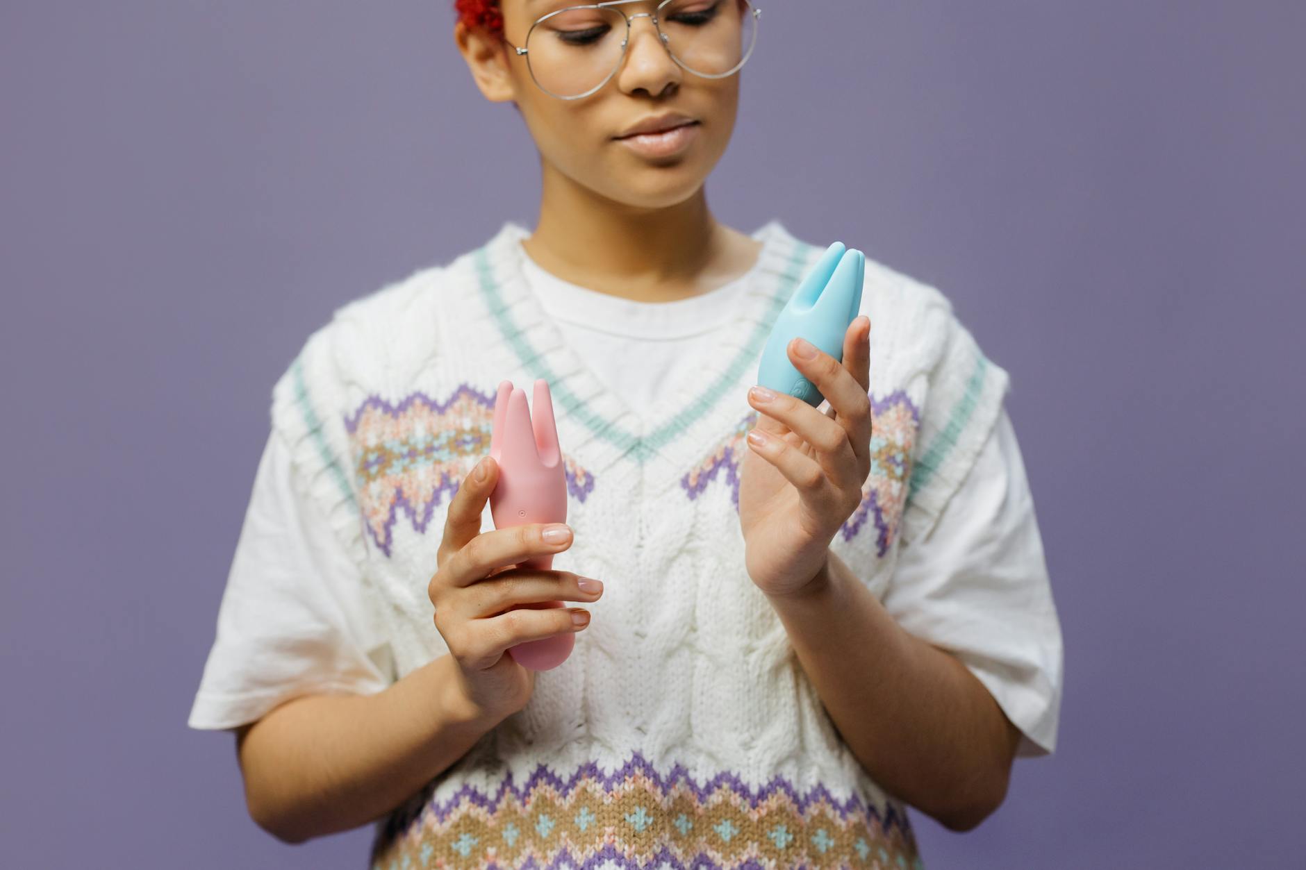 Woman holding silicone vibrators in hands, contemplating pleasure and wellness