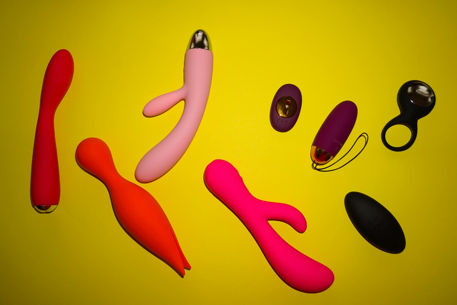 Hands holding pastel-colored silicone toys in an intimate setting