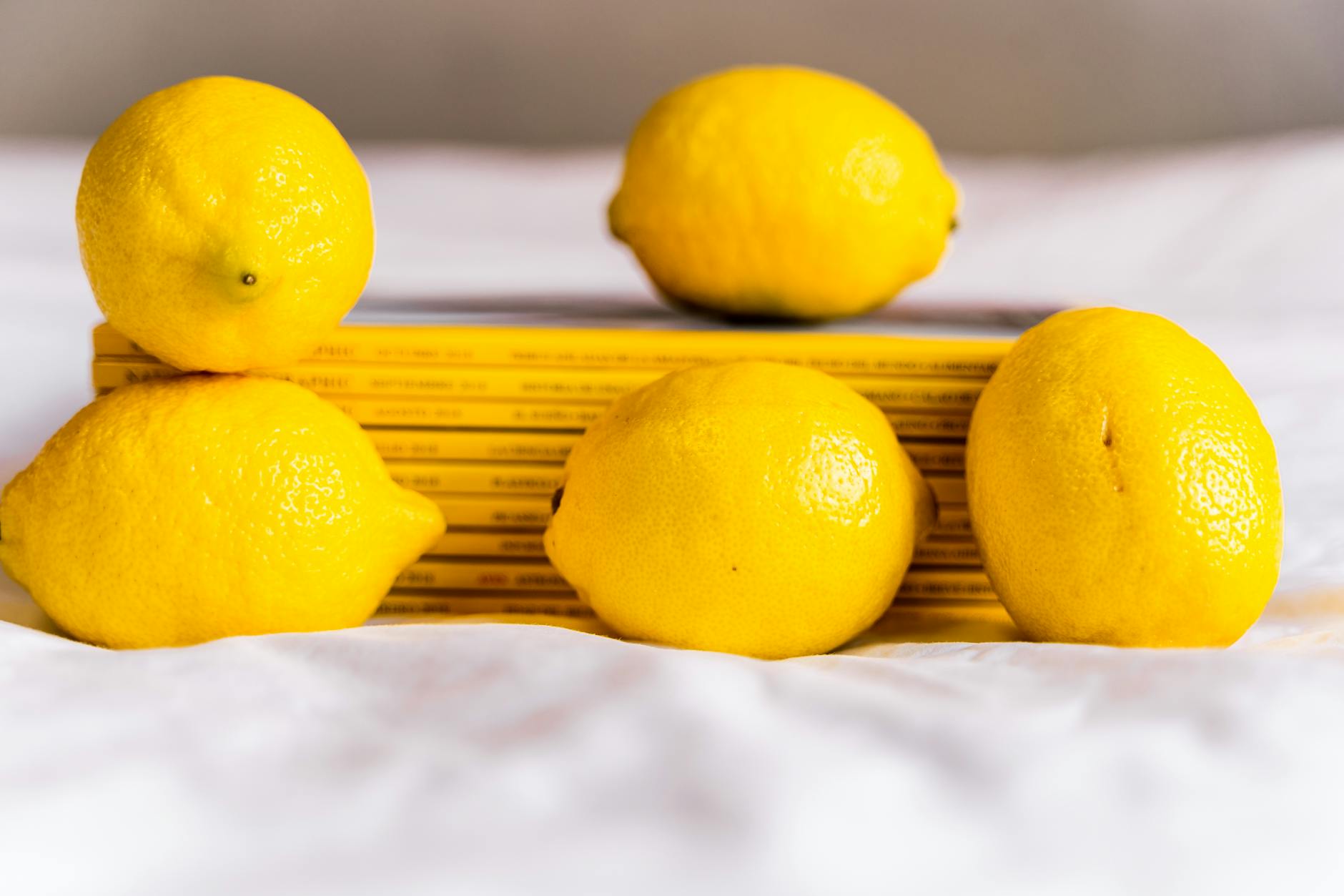 A sleek lemon vibrator on soft white silk, symbolizing gentle pleasure during hormonal transitions